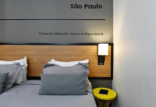 a bedroom with a bed with a wooden headboard at Monreale Lifestyle Higienópolis São Paulo in Sao Paulo