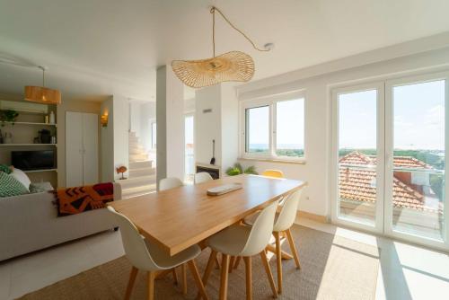 a kitchen and dining room with a wooden table and chairs at Dreamview Nest | By Airnest in Trafaria