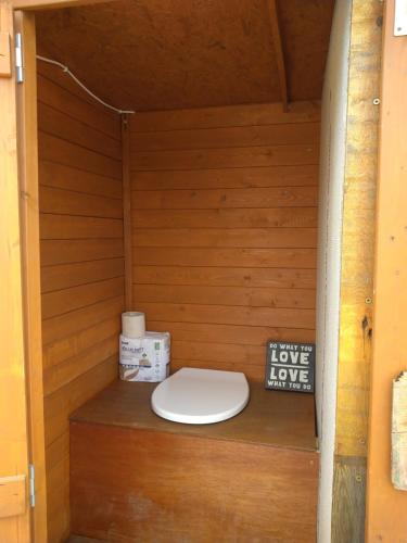 a bathroom with a toilet in a wooden wall at Organic Farmstay Glamping in St. Paul's Bay
