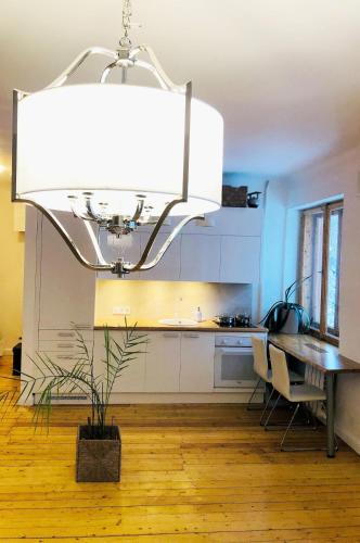a kitchen with a dining table and a chandelier at Self check-in spacious apartment in a quiet area in Rīga