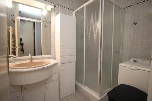 une salle de bain blanche avec un lavabo et une douche dans l'établissement Appartement 2 chambres vue mer, à Canet