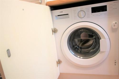 a white washing machine sitting in a room at Self check-in spacious apartment in a quiet area in Rīga
