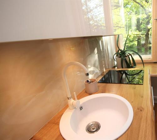 a white sink in a bathroom with a window at Self check-in spacious apartment in a quiet area in Rīga