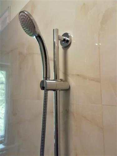 a shower with a shower head in a bathroom at Self check-in spacious apartment in a quiet area in Rīga