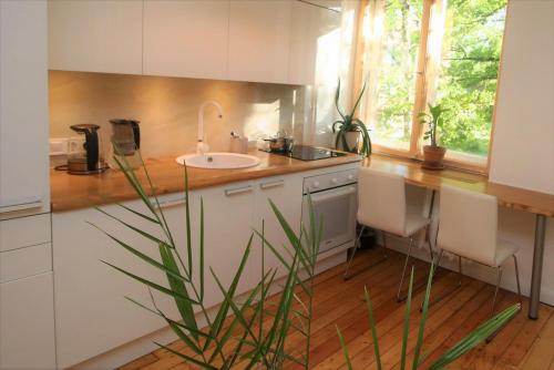 a kitchen with a sink and a counter with chairs at Self check-in spacious apartment in a quiet area in Rīga