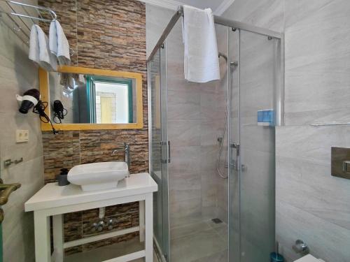 une salle de bains avec douche en verre et lavabo dans l'établissement İonic Alaçatı, à Çeşme