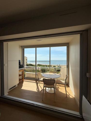 a room with a view of a table and chairs at Appt Rénové Palavas - 4 Personnes - Vue Mer - Parking - Rive Droite in Palavas-les-Flots
