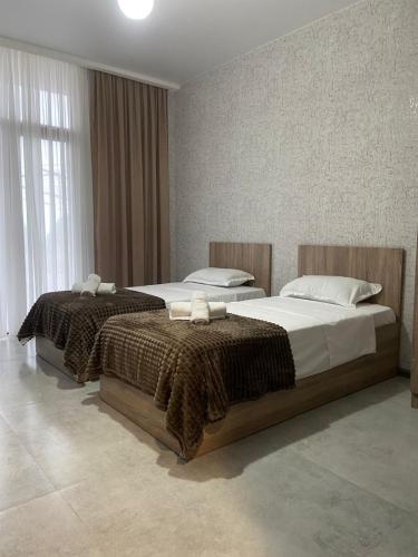 two beds in a hotel room withskirts at Leveta Botanical Garden in Batumi