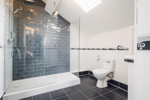 a bathroom with a tub and a toilet and a shower at White Lion Royal Hotel in Bala