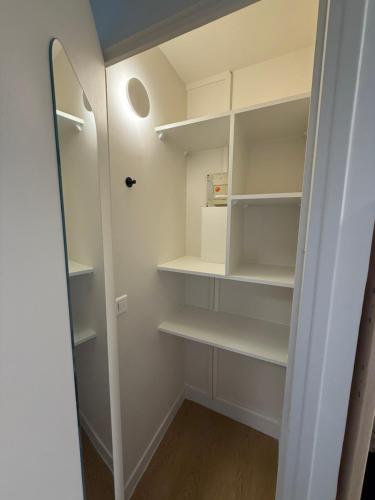 a walk in closet with white shelves and a mirror at Appt Rénové Palavas - 4 Personnes - Vue Mer - Parking - Rive Droite in Palavas-les-Flots