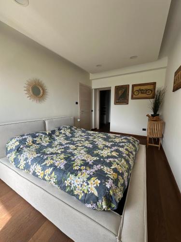 a bedroom with a bed with a floral bedspread at Bellagio Lake View apartment Rosabella with swimming-pool in Civenna