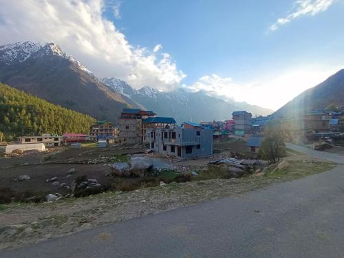 a town on a hill with mountains in the background at RR Homestay Chitkul in Chitkul