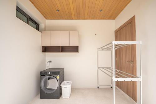a laundry room with a washer and dryer next to a door at Mouana Breeze Mai Khao 4-bedroom Pool Villa 9925 in Mai Khao Beach