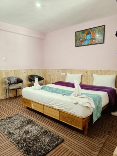 a bedroom with a large bed and a painting on the wall at RR Homestay Chitkul in Chitkul