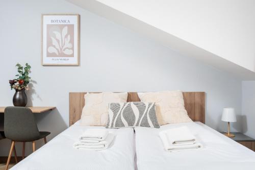 a bedroom with a white bed with a desk and chairs at Nowy Hotel Monika - by Upstairs in Kraków