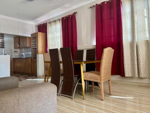 a dining room with red curtains and a table and chairs at Veranda Vista in Trofwi