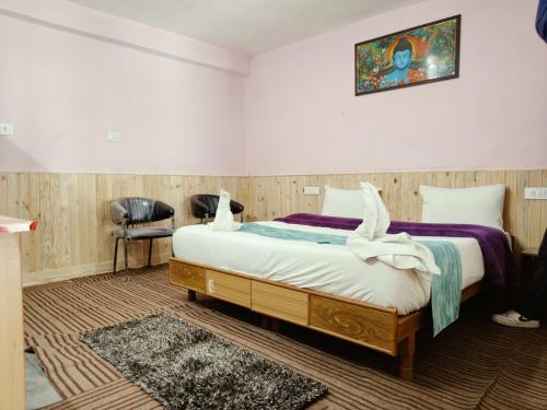 a bedroom with a bed with two swans on it at RR Homestay Chitkul in Chitkul