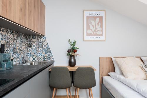 a small kitchen with a table and two chairs at Nowy Hotel Monika - by Upstairs in Kraków