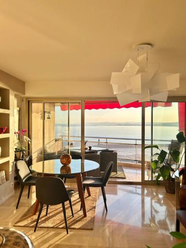 une salle à manger avec une table et une vue sur l'océan dans l'établissement Magnifique appartement - Vue mer, à Nice