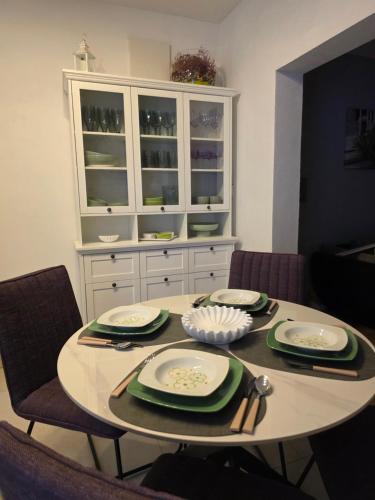 a dining room table with chairs and a white hutch at Apartments Ita - Postira in Postira