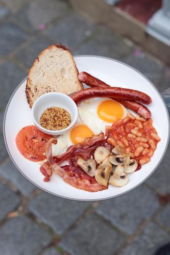 Un plato de desayuno con huevos, tocino y tostadas. en Klimatyczna Kamienica w Centrum Torunia - Garbary 12 by 2HomeRent, en Toruń