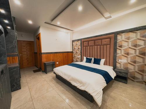 a bedroom with a large bed and a bathroom at Tara Van in Dharamshala