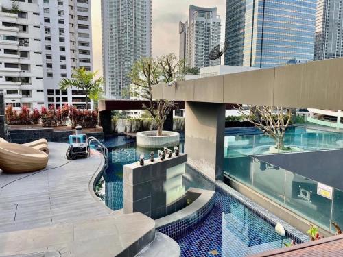 a pool in the middle of a city with tall buildings at CozyroomSukumvit13walktoBTS,MRT in Bangkok