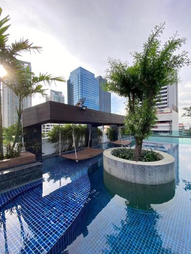 a swimming pool with a tree in the middle of a building at CozyroomSukumvit13walktoBTS,MRT in Bangkok