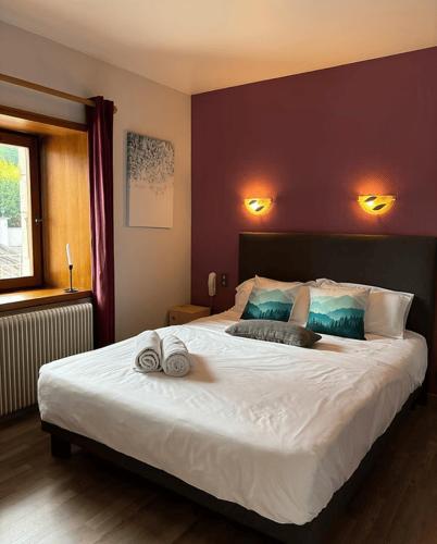 une chambre avec un grand lit avec deux serviettes dessus dans l'établissement L'auberge de Mégevette, à Mégevette
