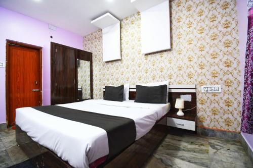 a bedroom with a large bed in a room at Hotel Satya Inn in Bhubaneshwar