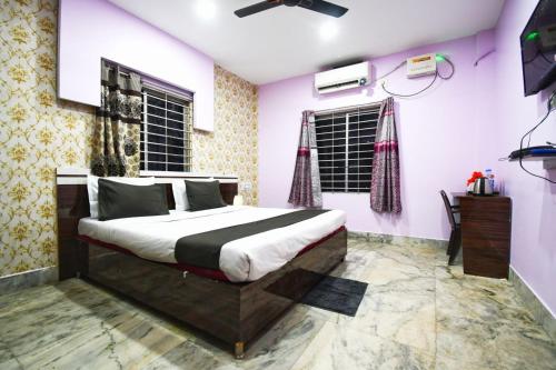 a bedroom with a bed and a tv in it at Hotel Satya Inn in Bhubaneshwar