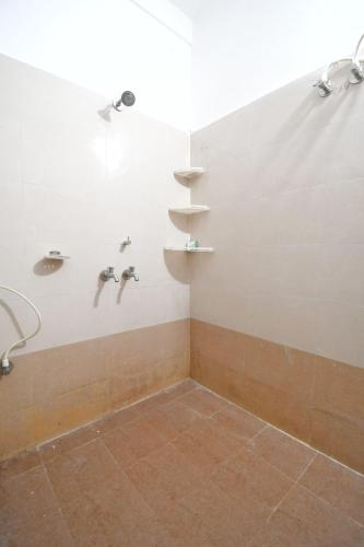 a bathroom with a shower with two faucets at Hotel Satya Inn in Bhubaneshwar
