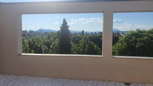 a window in a room with a view of trees at Loft Apartment in Podgorica