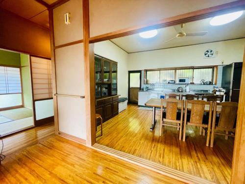 a dining room with a table and a kitchen at ぽつんとオーシャンビューでバーベキューも出来る1日1組貸切宿カゴヤブハウス in Otsuki