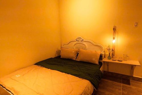 a bedroom with a bed and a side table at Villa Nhà có hai cây Tùng in Bao Loc