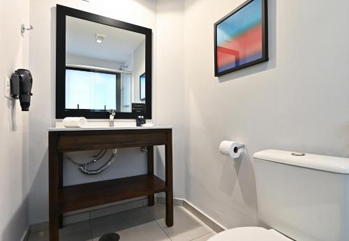 a bathroom with a sink and a mirror and a toilet at Monreale Lifestyle Higienópolis São Paulo in Sao Paulo