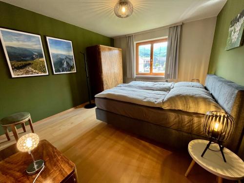a bedroom with green walls and a bed and a table at Salzkammergut Hideaway RUDOLPH in Bad Ischl