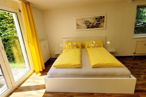 a bedroom with a bed with yellow sheets and a window at Top2 Apartmenthaus Sonnenschein in Dornbirn