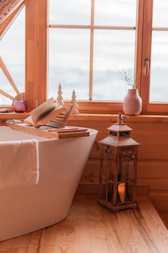 a bathroom with a bath tub with books and a lantern at Marusina Chalets in Szaflary