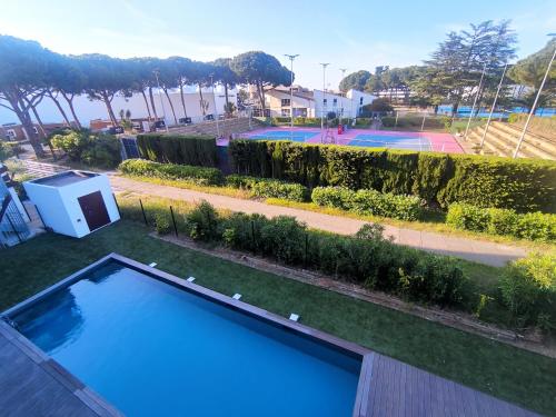 - une piscine dans une cour avec un court de tennis dans l'établissement Studio 218, WELLNESS Cap d'Agde, Centre de Tennis, au Cap d'Agde