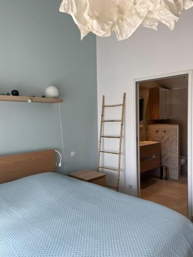 une chambre avec un lit et une pièce avec une échelle dans l'établissement Maison proche plages, au calme, piscine et parking, à Anglet