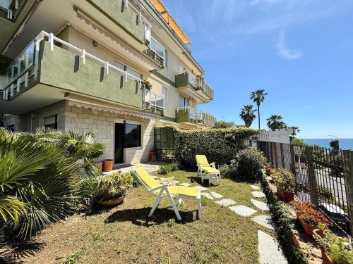 a house with two yellow chairs in the yard at Suite Mazzini 177 - Sanremo in Sanremo