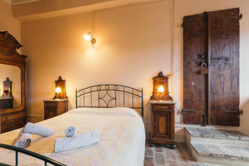 a bedroom with a bed and two night stands with towels at Dimora Bruschi in Pergola
