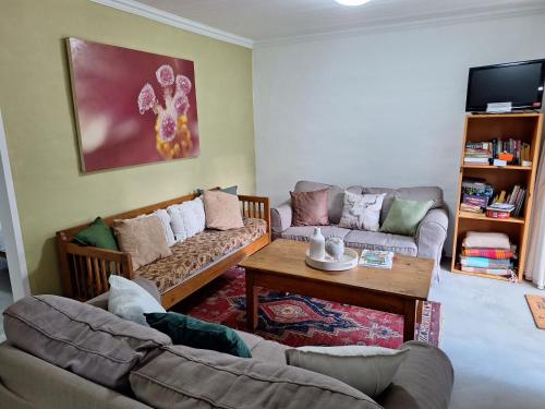 a living room with two couches and a coffee table at L Chiam Self-Catering Cottage in Winterton