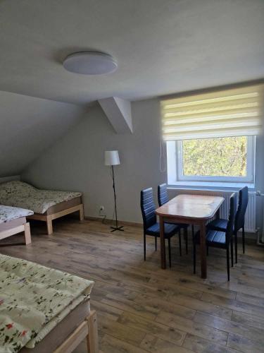 a room with a table and chairs and a window at Pokoje pracownicze przy DK 51 in Lidzbark Warmiński