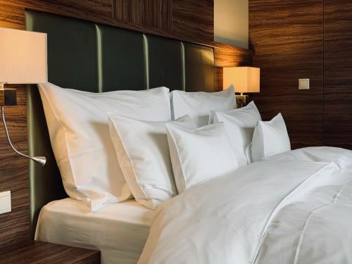 duże łóżko z białymi poduszkami w sypialni w obiekcie Barack Thermal Hotel and Spa w mieście Tiszakécske