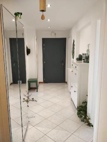 un couloir avec une porte noire et du carrelage. dans l'établissement Strasbourg Centre Historique 15 mn en Tram et Aéroport Parking gratuit, à Lingolsheim