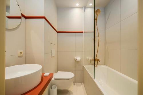 a bathroom with a sink and a toilet and a tub at The Queen's Twelve by Romy&Travis in Bruges