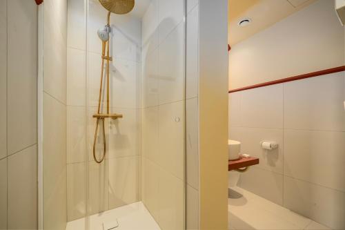 a shower with a glass door in a bathroom at The Queen's Twelve by Romy&Travis in Bruges