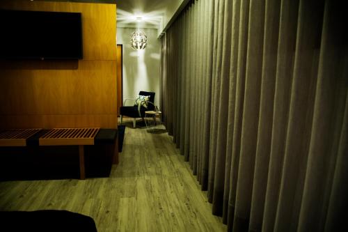 a corridor of a hotel room with a couch and a chair at Villa Prime Hotel in Vila Nova de Famalicão